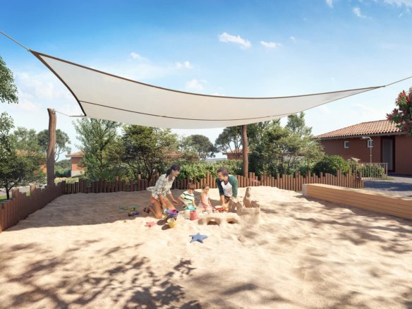 Espaço infantil de areia com cobertura de tecido e crianças brincando.