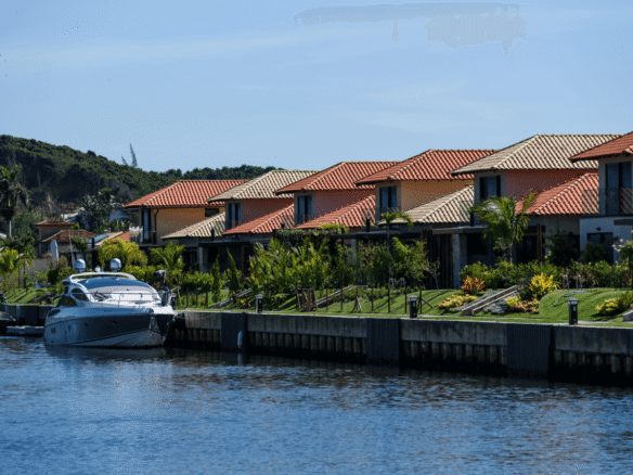 Embarcação atracada em canal diante de casas com telhados de cerâmica.
