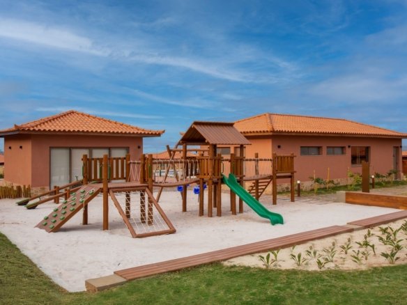 Espaço criança ao ar livre, com brinquedos de madeira sobre a areia, no Alto Ybirá (foto real)