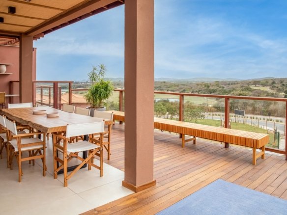 Varanda coberta com mesa de refeições e banco de madeira, com vista para o campo, no Alto Ybirá (foto real)