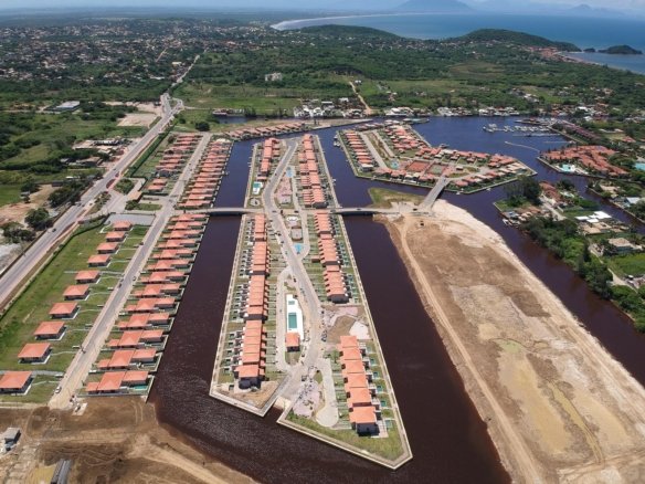 Vista aérea das ilhas de casas do Toriba entre os canais, com áreas ainda sem casas à direita (foto real)