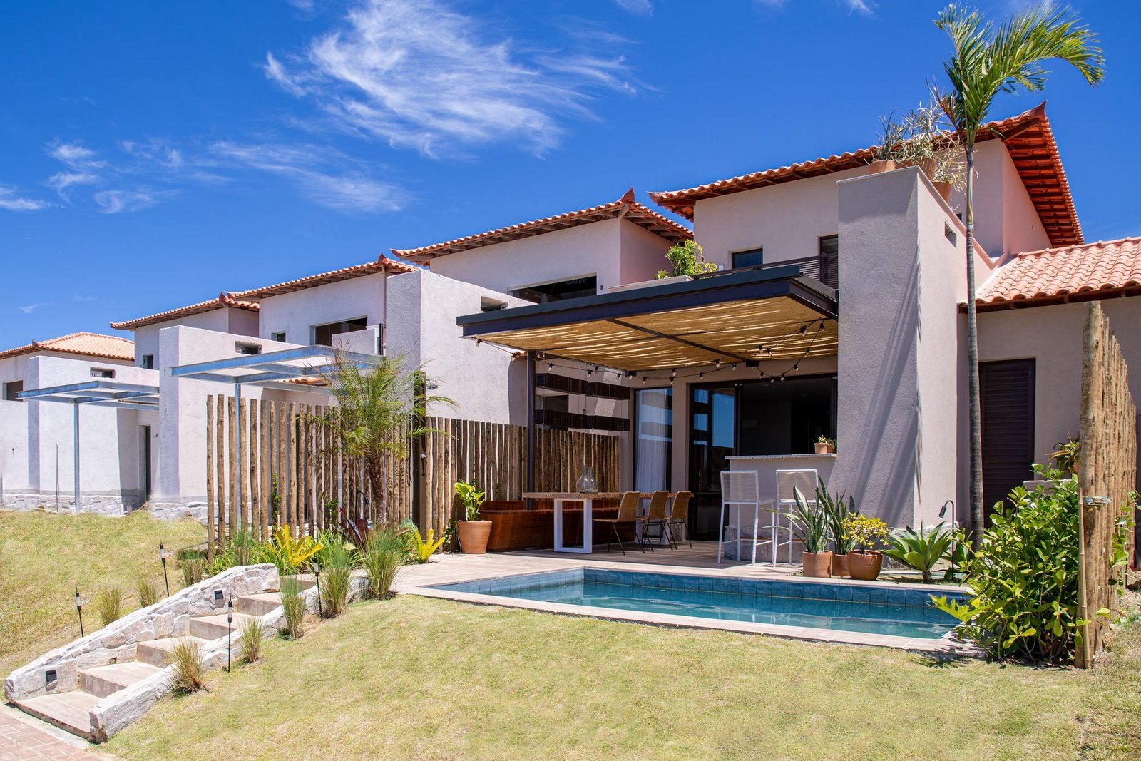 Fundos da casa 10 do Condomínio B do Toriba Norte, com piscina, jardim em degraus e pergolado (foto real)