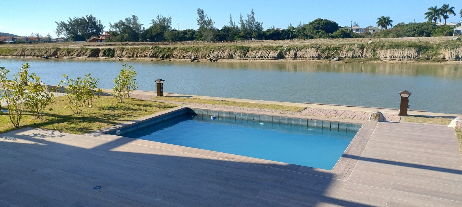 phoco-sync-619fd466ff06a5c0-576b6d3b5b8a Piscina e deck de uma casa do Toriba Sul, com o canal logo atrás (foto real)