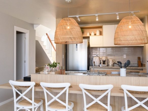 Cozinha decorada da casa 9 do Condomínio A do Toriba Norte, com bancada, banquetas e luminárias de palha (foto real)