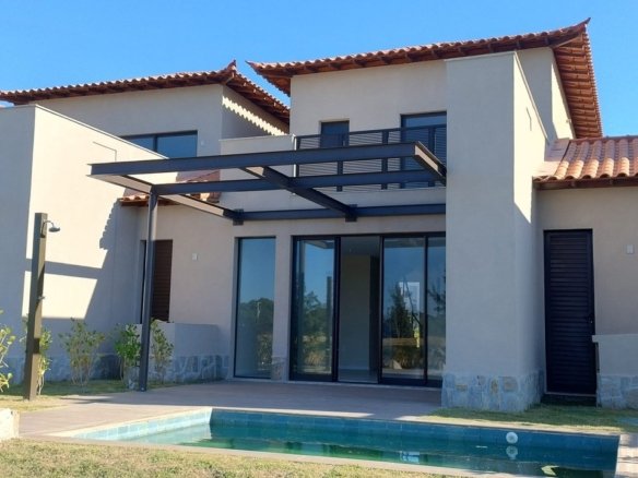 Fundos de uma casa do Toriba Sul, com pergolado, piscina e grama recém-plantada (foto real)