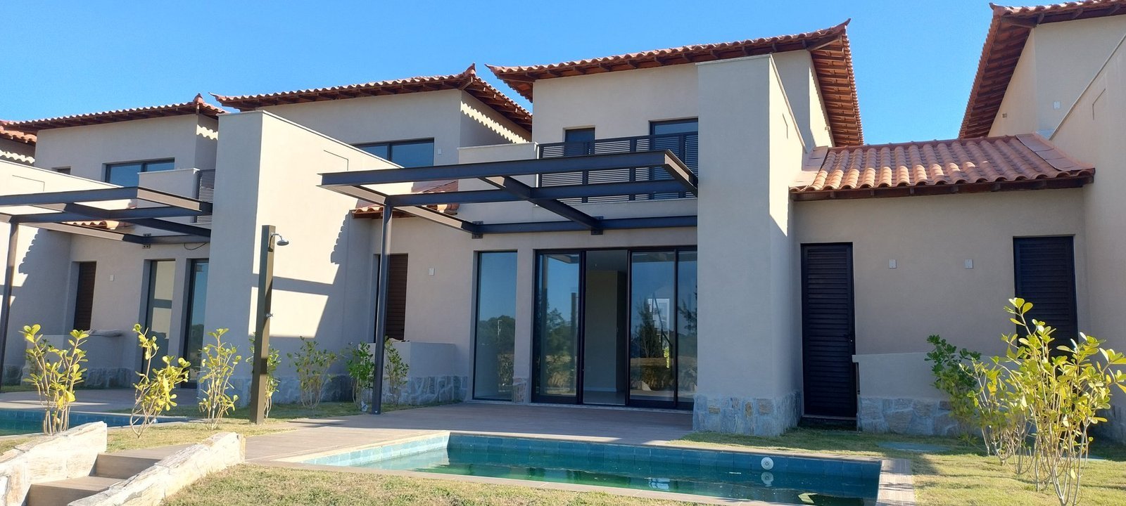 phoco-sync-acec4c24d91df5bf-1ad656bb7010 Fundos de uma casa do Toriba Sul, com pergolado, piscina e grama recém-plantada (foto real)