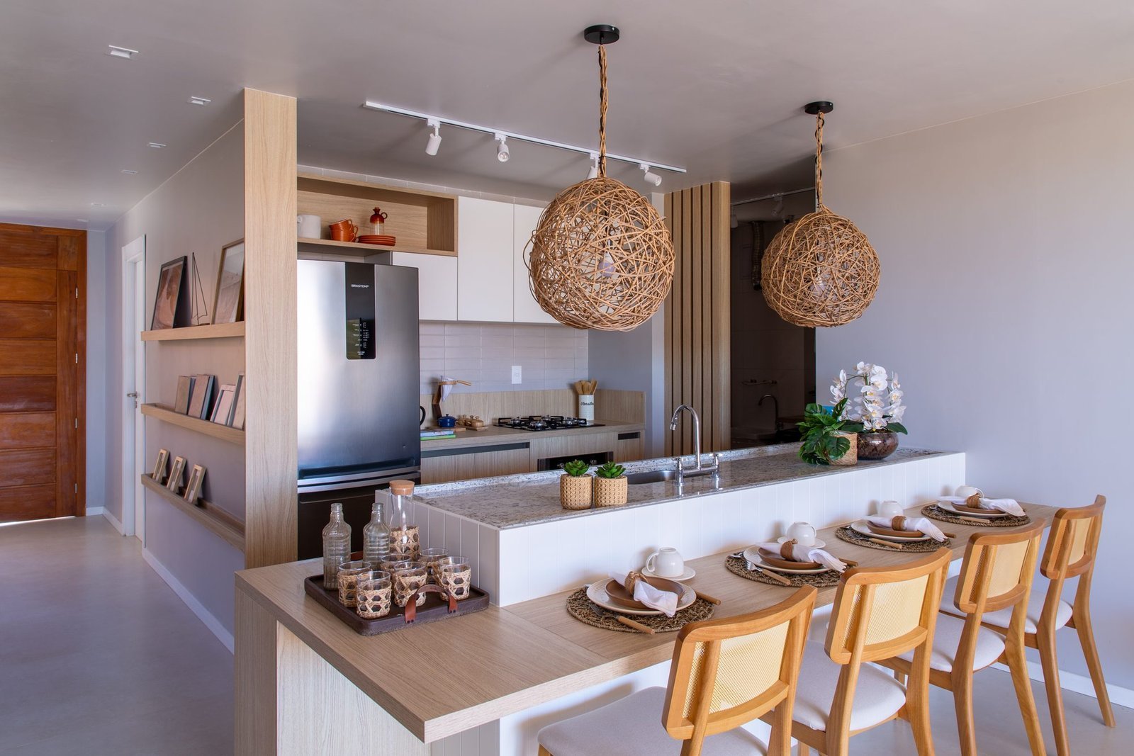 Cozinha integrada decorada da casa 10 do Condomínio B do Toriba Norte, com bancada e banquetas (foto real)