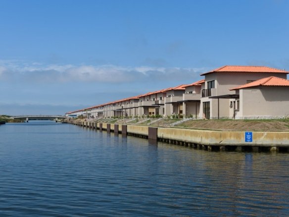 Canal do Toriba Norte, com a fileira de casas à margem e uma ponte ao fundo (foto real)