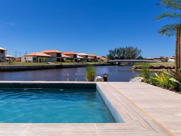 Piscina da casa 10 do Condomínio B do Toriba Norte, com deck de madeira e o canal ao lado (foto real)