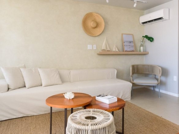 Sala de estar decorada da casa 9 do Condomínio A do Toriba Norte, com sofá e mesas de centro (foto real)